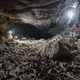 A researcher sits next to a massive bone bed in a Saudi cave.